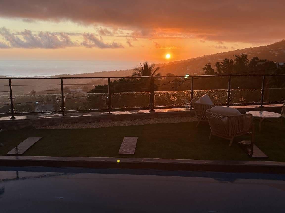 Coucher de soleil sur l'océan depuis la terrasse et la piscine d'une villa Gramys