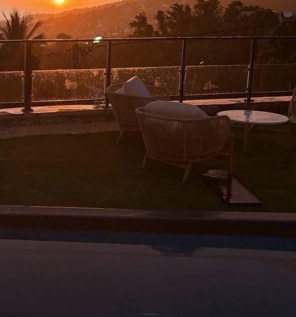 Fauteuils de jardin face à l'océan au coucher du soleil
